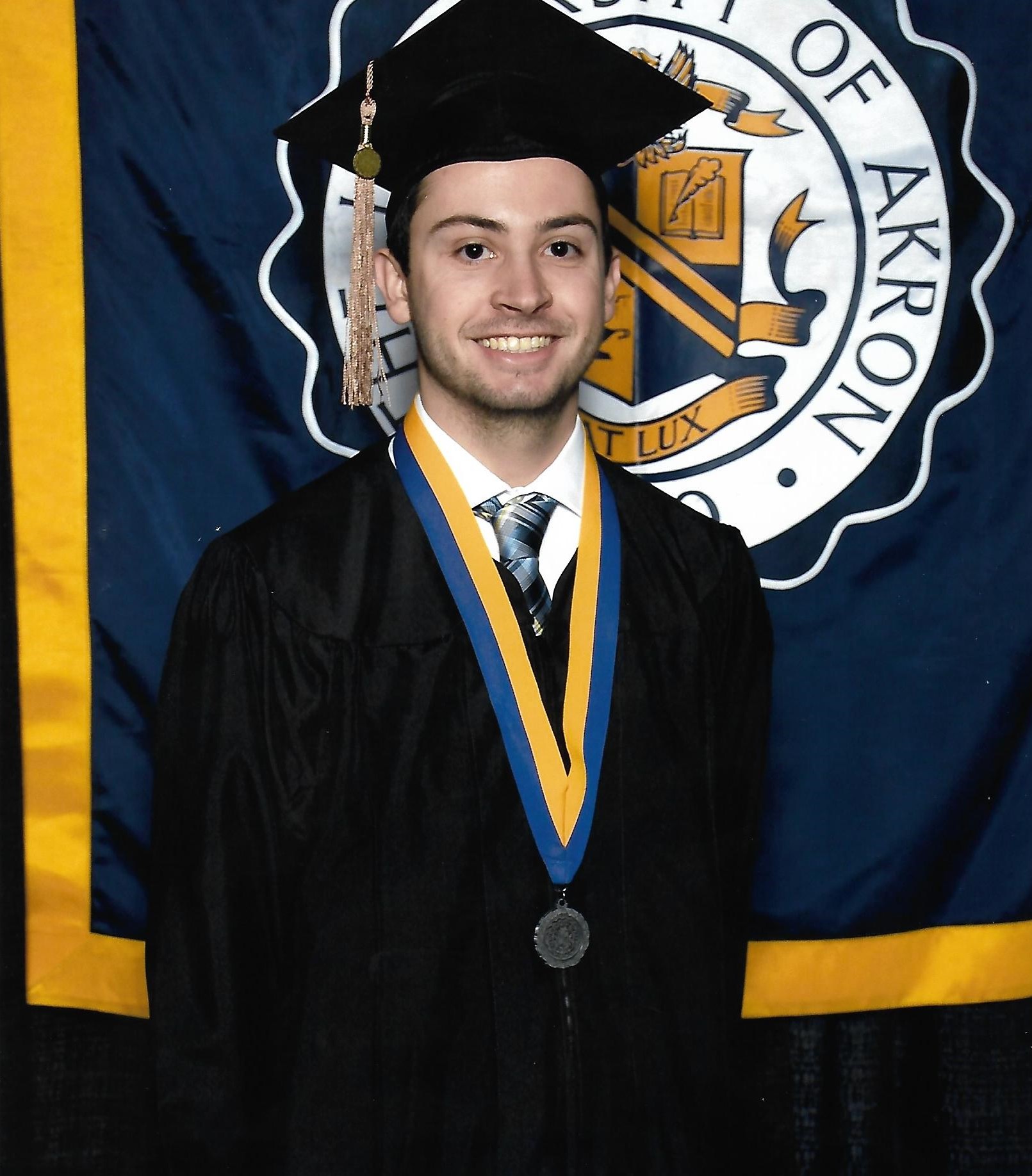 A picture of Chase at college graduation in cap and gown